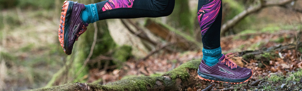 Pair of Bridgedale trail socks worn by a runner in the woods